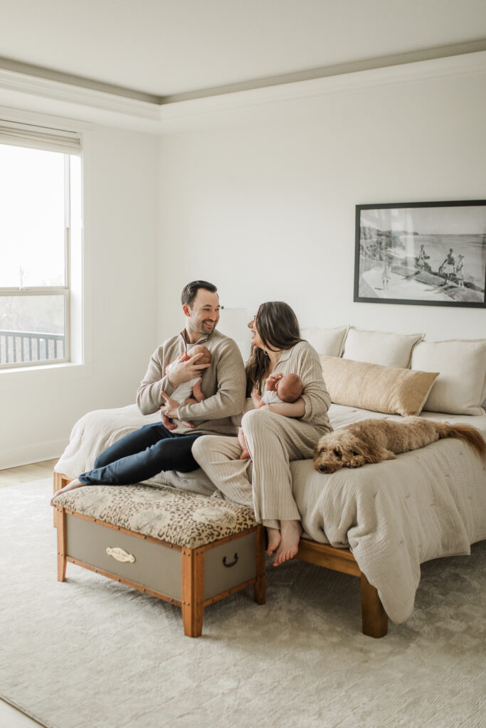 Twin newborn photo session in home with the family on their bed in their primary bedroom.