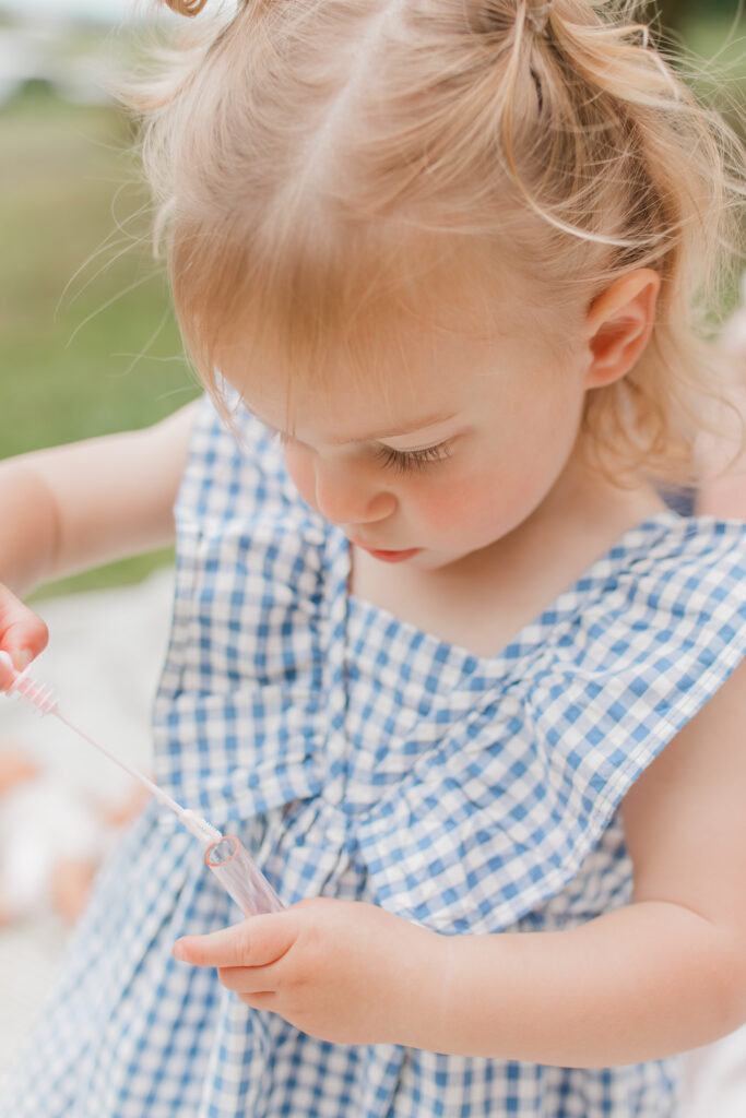 toddler blowing bubbles for backyard family photos