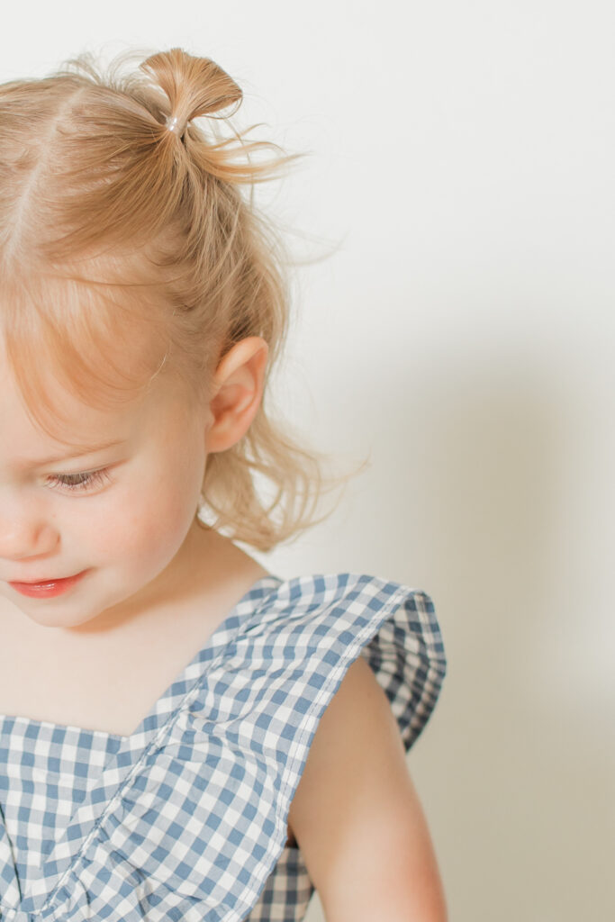 a detail photo of a toddler girl's face with long eyelashes and curly blond hair