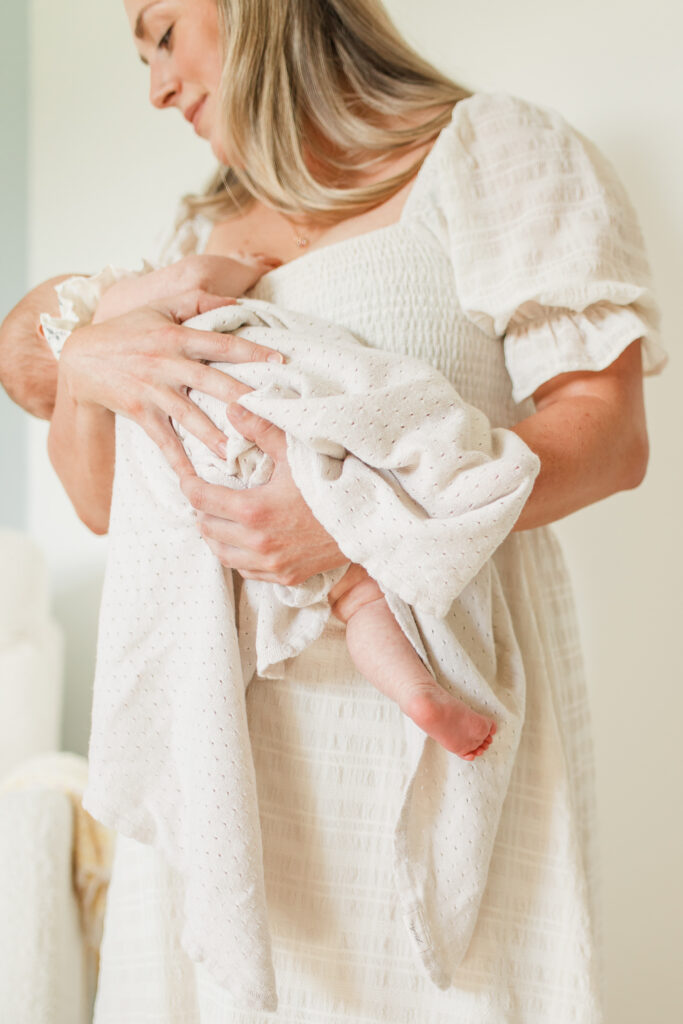 a mother lovingly gazes down at her newborn baby girl 