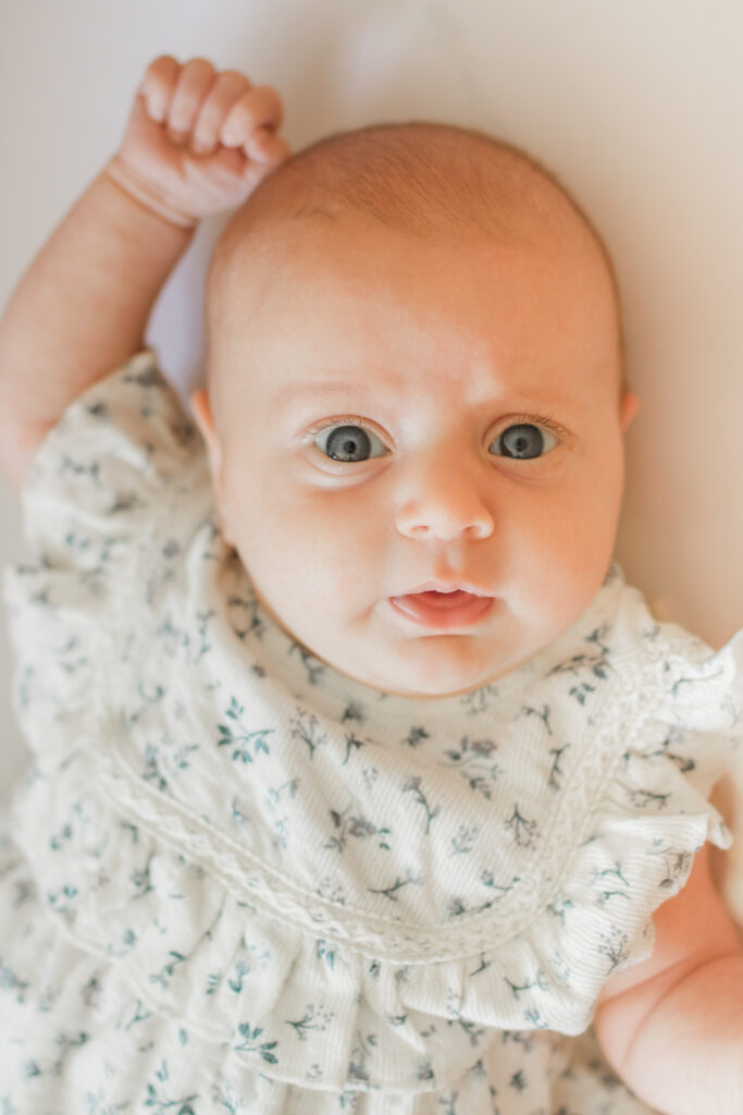 a close up photo of a newborn baby girl looking right into the camera