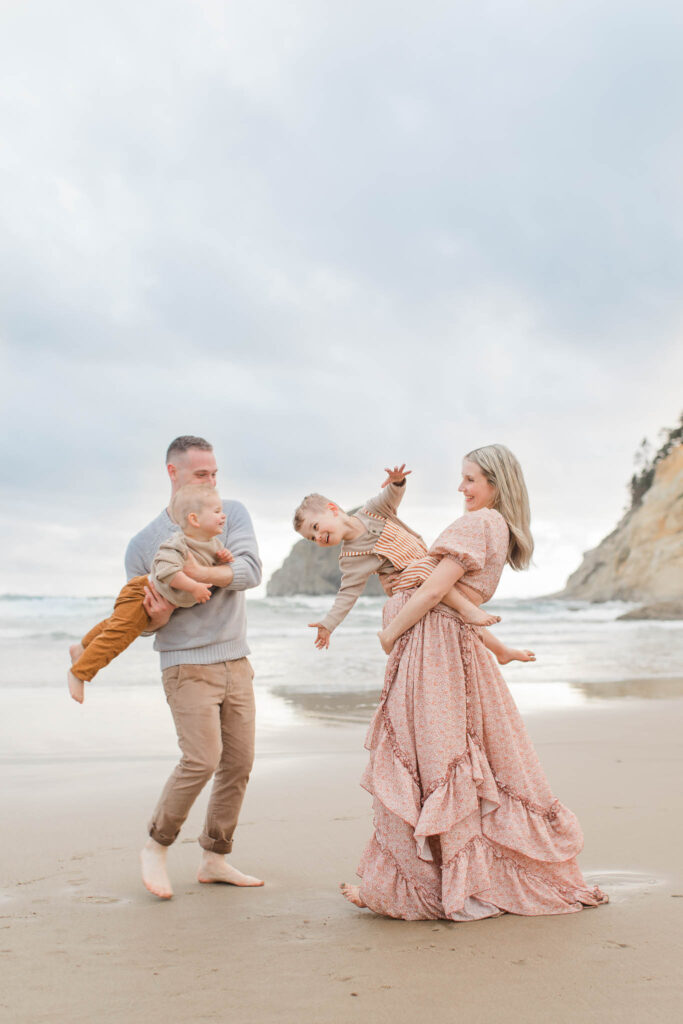 Family walking along Oregon Coast beach during maternity session