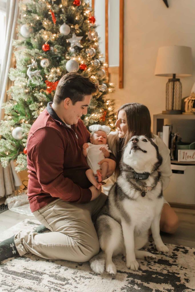 Parents holding newborn during holiday in-home photo session taken by a Vancouver WA newborn photographer