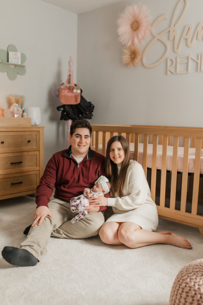 Parents holding newborn during in-home photo session taken by a Vancouver WA newborn photographer