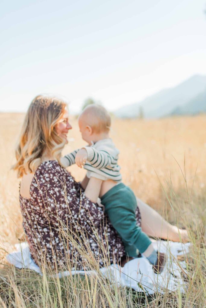 Soft, candid moment between mother and baby outdoors during a Mama and Me photos session taken by a Camas WA motherhood photographer