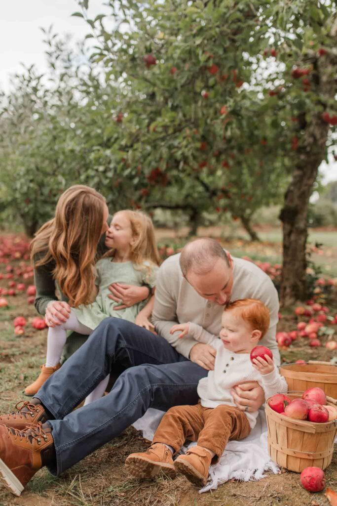 family of four with two toddlers enjoys their time at a apple orchard for their fall family photo session
