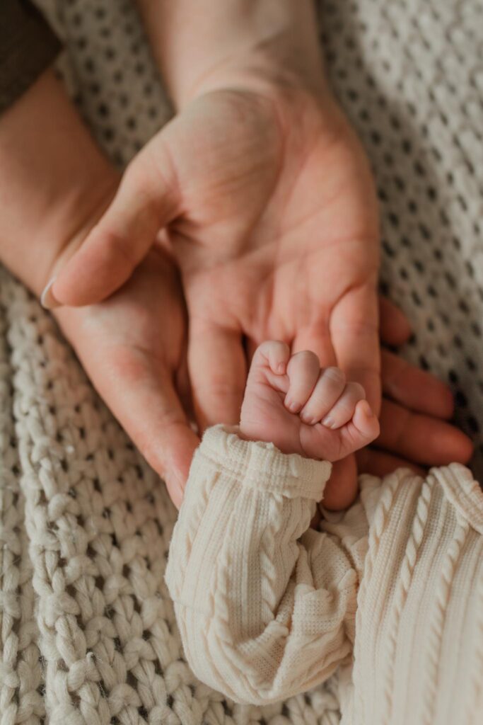 Close-up detail photo of newborn hands for a private baby announcement by an in-home lifestyle newborn photographer in Portland OR