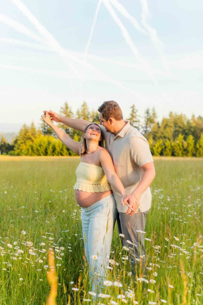 Camas WA maternity photographer photographing an expecting couple surrounded by blooming wildflowers.