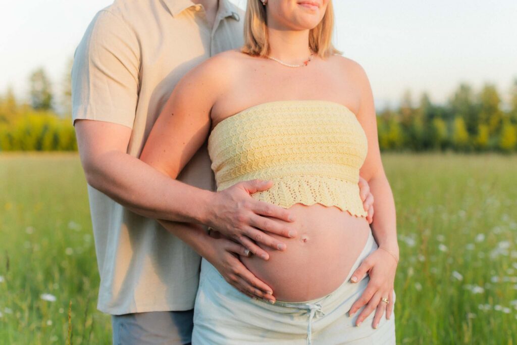 Romantic sunset maternity photo in a blooming wildflower field near Camas, Washington.