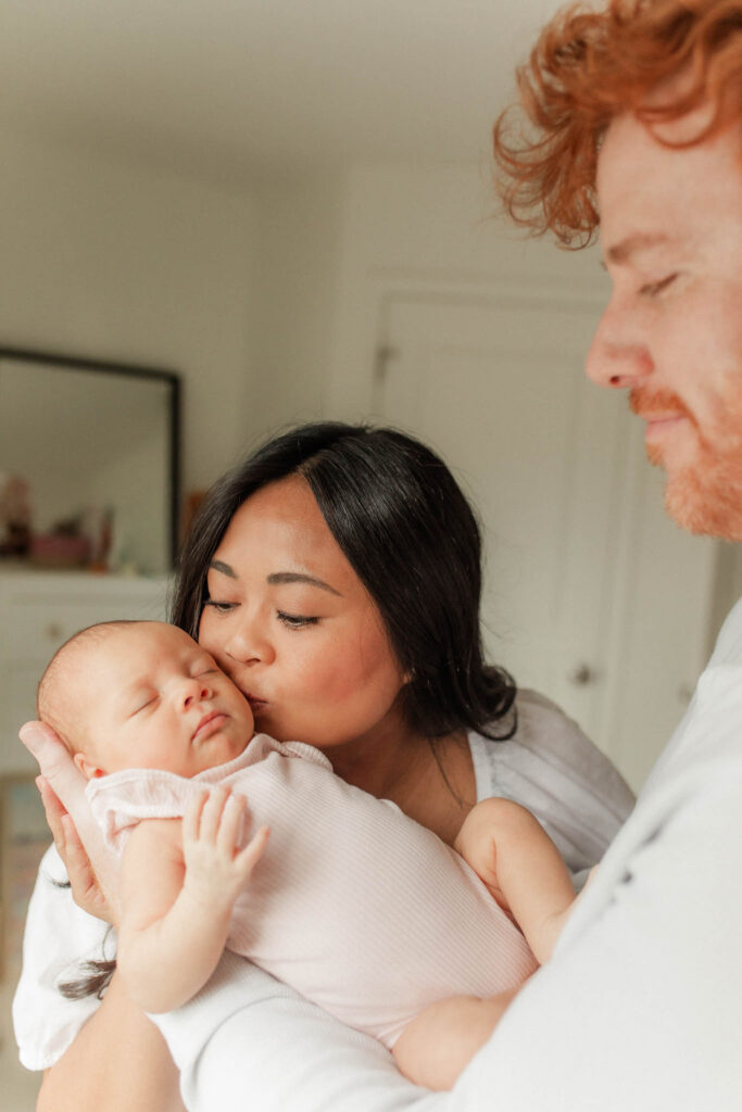 Newborn baby sleeping peacefully in parents' arms during a Washougal WA in-home newborn photography session