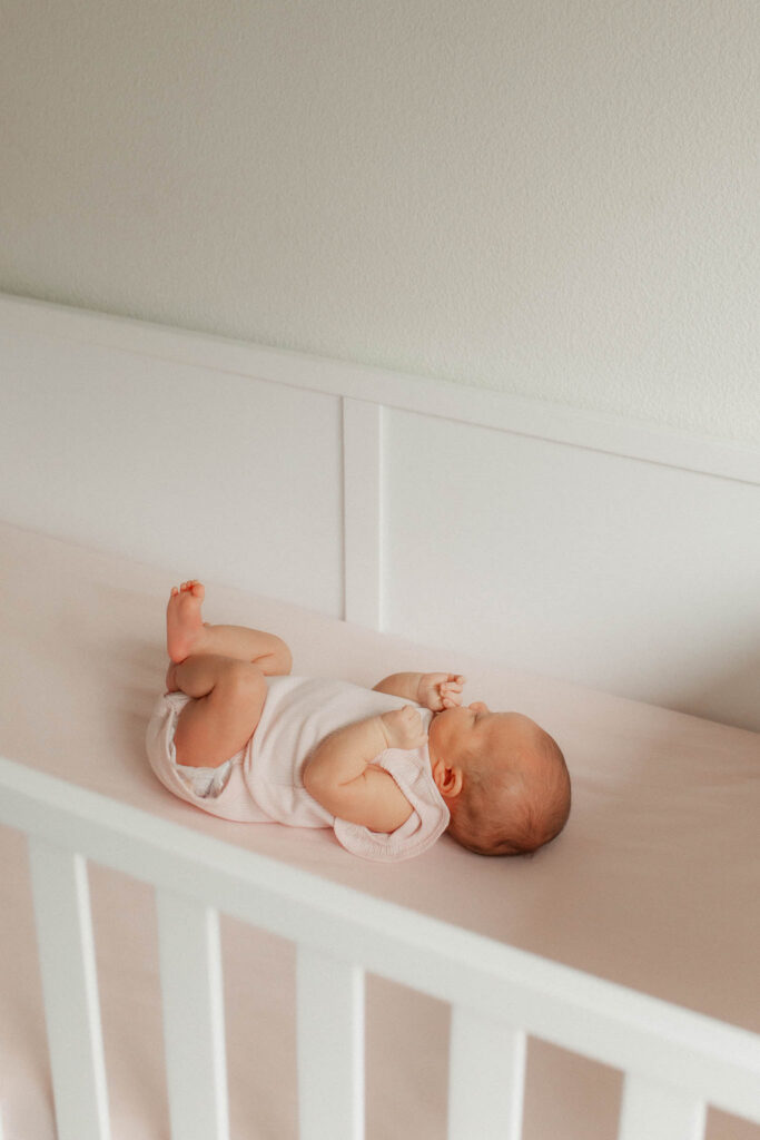 Newborn baby squish in her pink crib during a Washougal WA in-home newborn photography session
