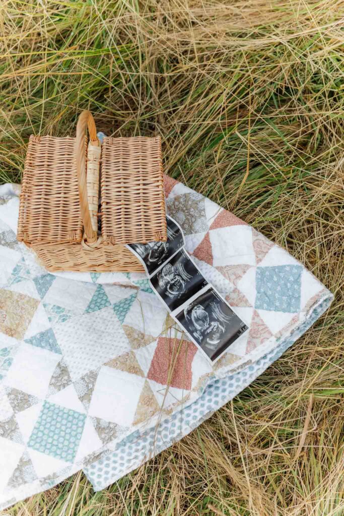Ultrasound photos placed in a basket resting on a quilt during a western-inspired maternity session
